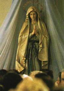 Estátua da Virgem Maria rezando na Igreja de São Tiago, Medjugorje. A Virgem precisa das orações de seus filhos para levar cada um à salvação e para alcançar a conversão do mundo e o que ela se referiu como "uma era de paz"
